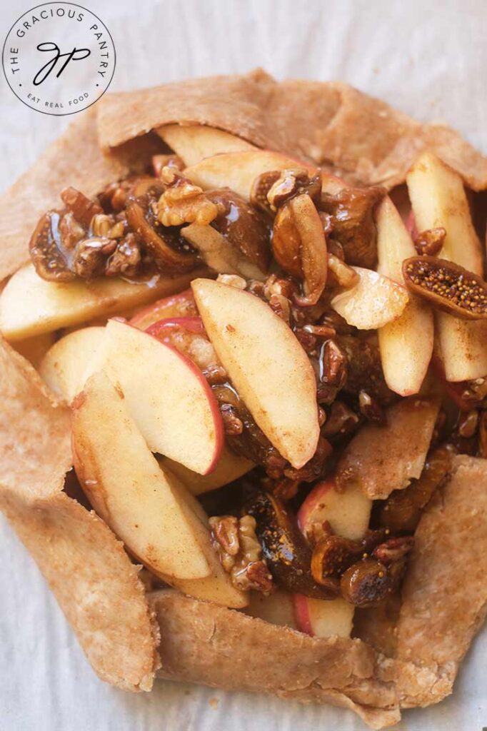 An unbaked Fig Galette sitting on white parchment paper.