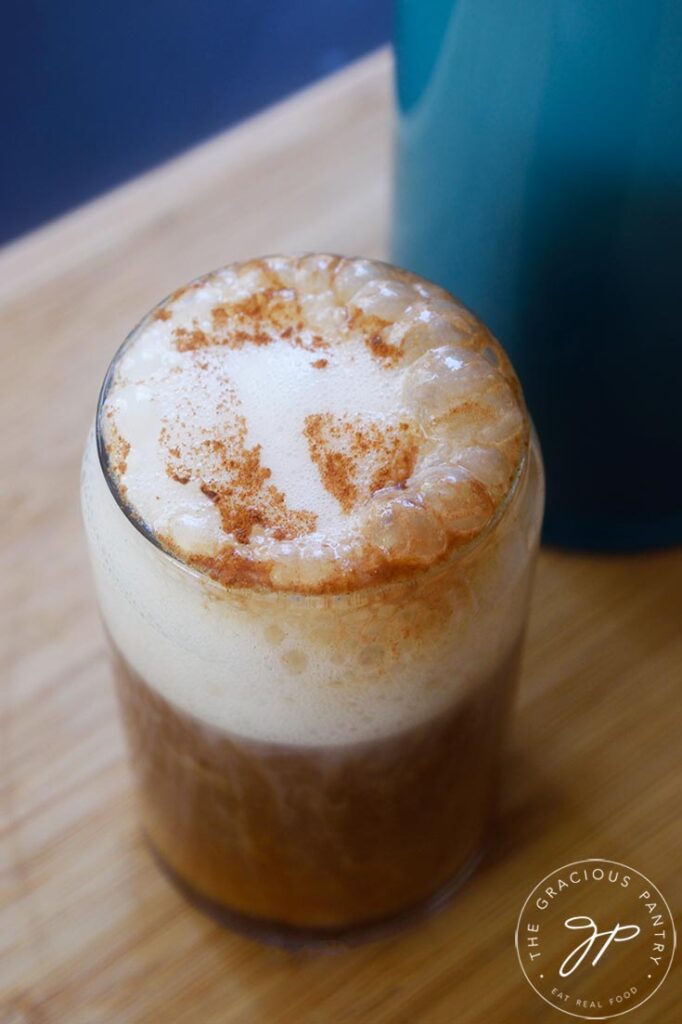 An angled view of a glass cup filled with a Healthy Pumpkin Spice Latte.