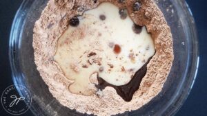 Milk and oil added to a dry flour mixture for cauldron cakes.