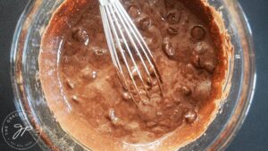 Cauldron Cake batter in a mixing bowl with a whisk.