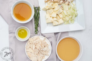 All ingredients for this Chicken And Parsnip Soup Recipe gathered in individual white plates and bowls.