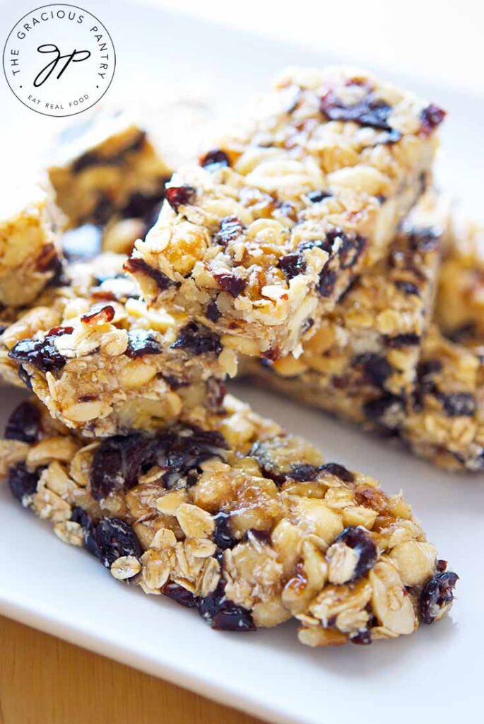 A closeup of several Coconut Granola Bars stacked on a white plate.