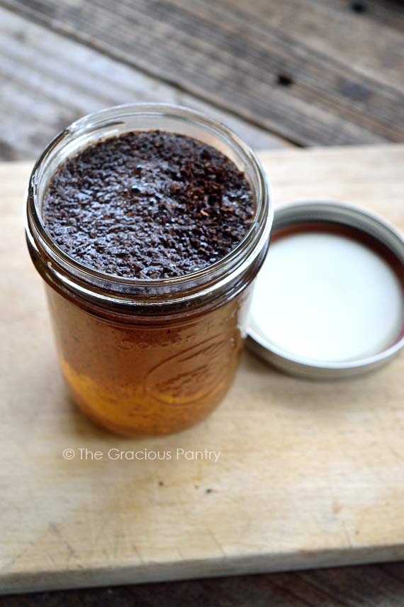 The water and coffee grounds sitting in a mason jar.