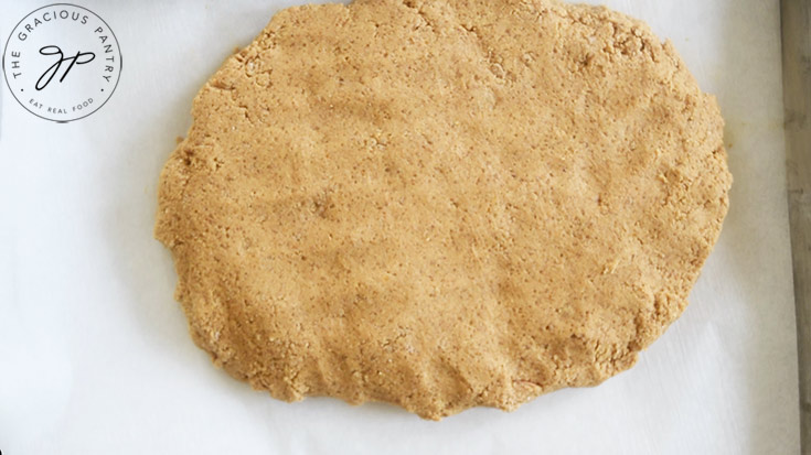 Gluten-Free Pumpkin Biscotti dough, formed into an oval, sitting on a parchment-lined cookie sheet.