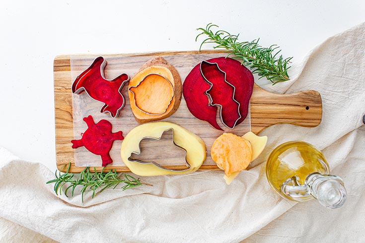 Slices of root vegetables with cookie cutters on them.