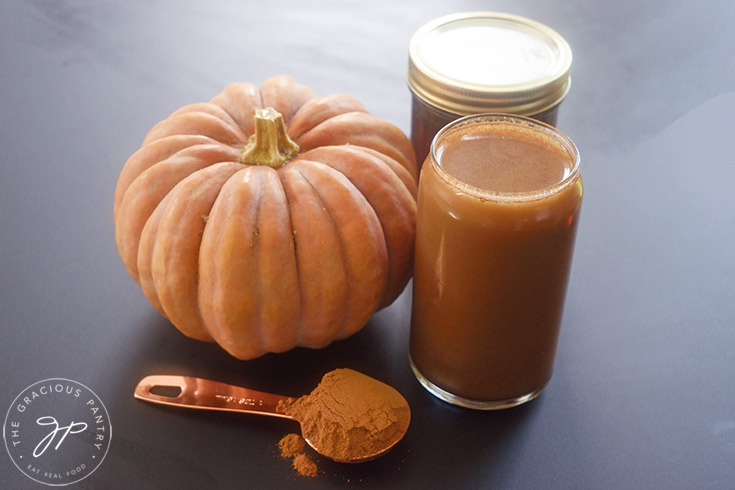 Pumpkin Spice Cold Brew Coffee in a glass next to a pumpkin.