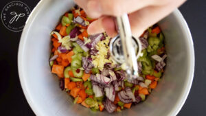 Pressing garlic cloves into a slow cooker crock.