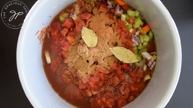 Spices added to vegetables and lentils in a slow cooker crock.