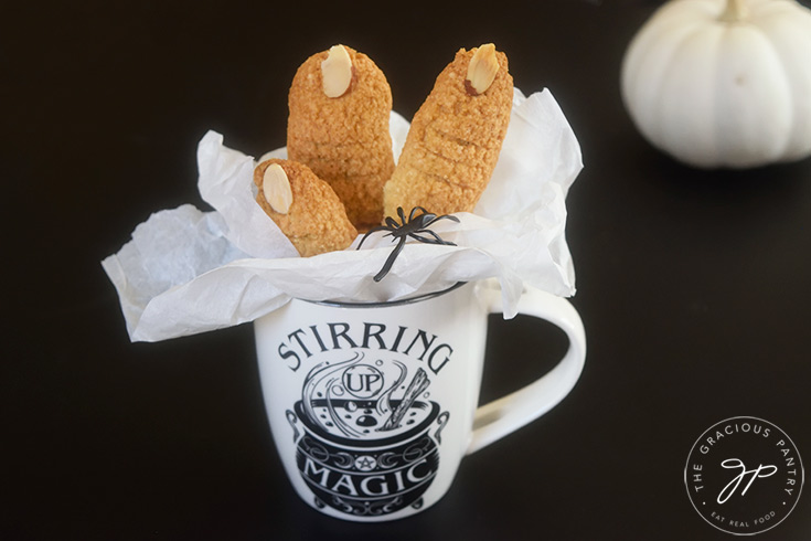 The finished Witch Finger Cookies nestled into parchment inside of a halloween mug.