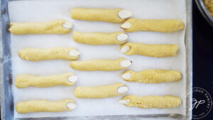 Sliced almonds pressed into the ends of the dough pieces to create the fingernails on Witch Finger Cookies.