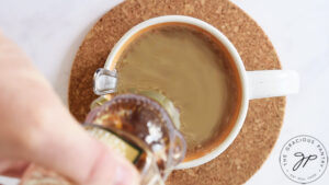 Adding honey to a cup of coffee.