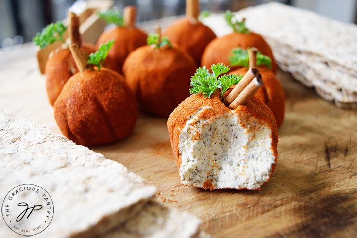 A group of Cream Cheese Balls on a cutting board between some crackers.