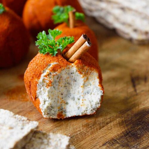 A single cheese ball with a portion taken out of it.