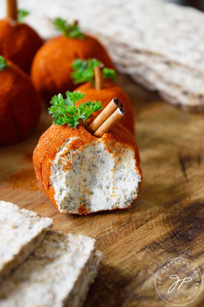 A single cheese ball with a portion taken out of it.