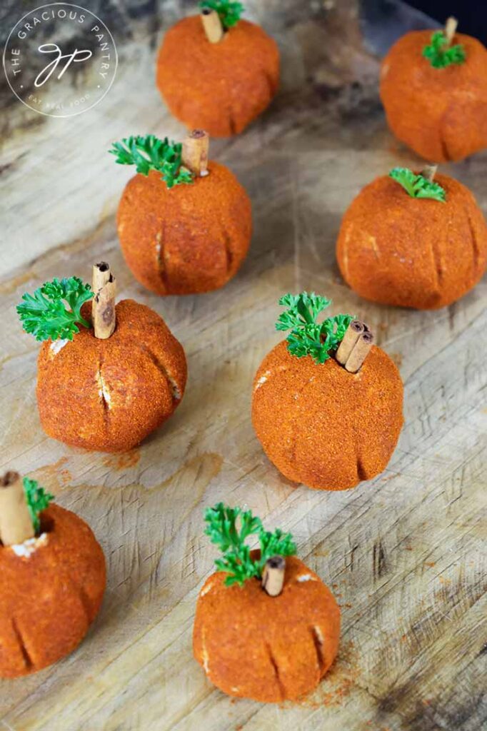 Two rows of Cream Cheese Balls lined up on a wooden cutting board.