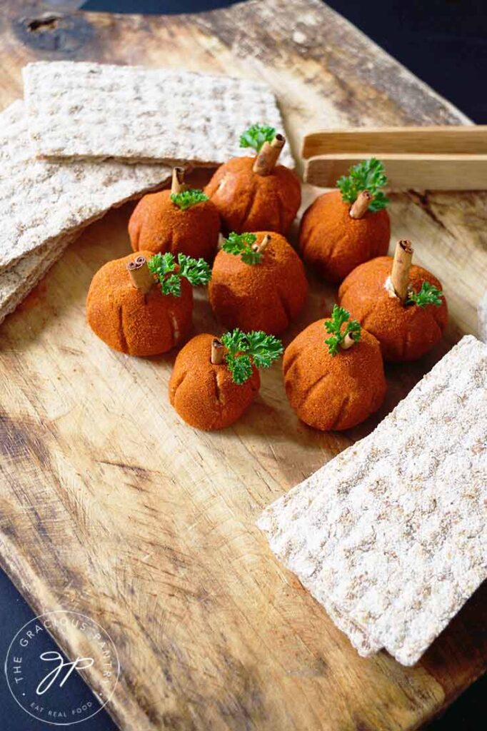 Cream Cheese Balls sitting in a circle on a cutting board, surrounded by crackers.