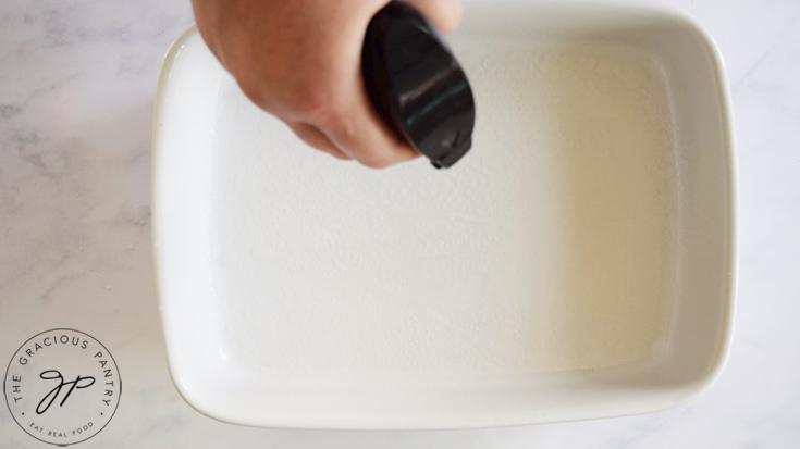 Spraying a casserole dish with oil.