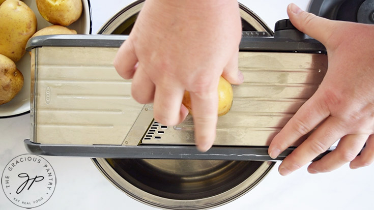 Slicing potatoes on a mandoline.