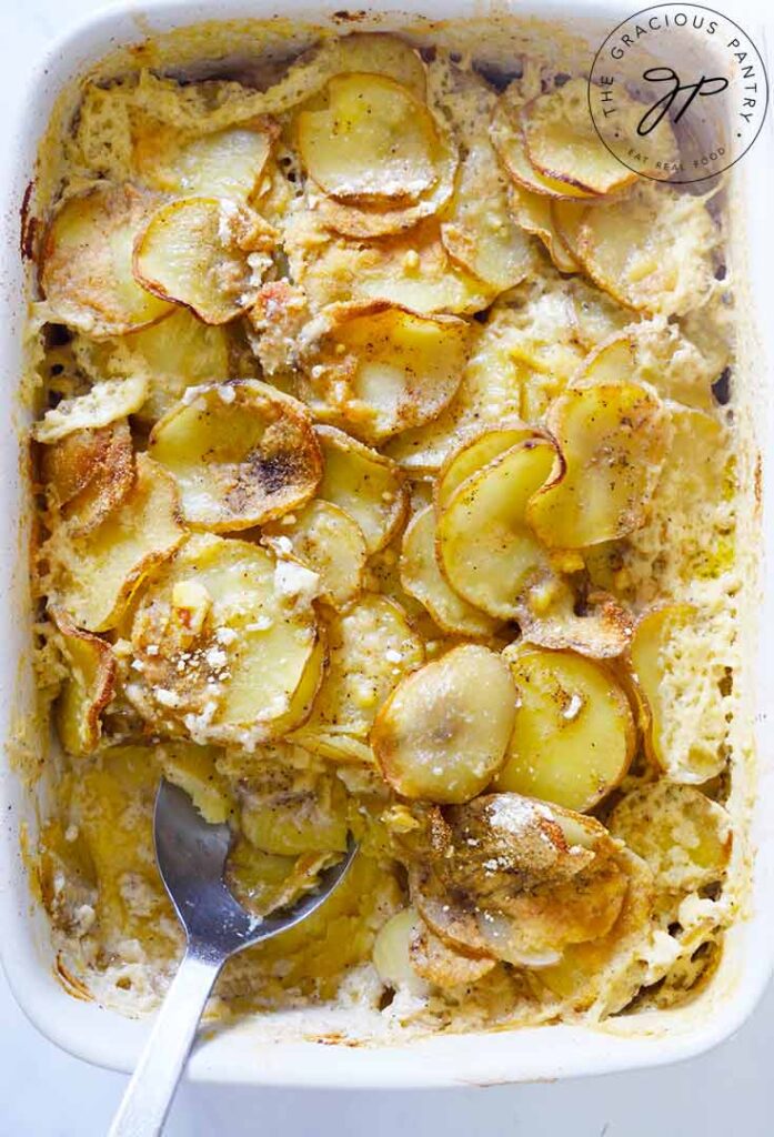 An overhead view of a white casserole dish filled with Healthy Scalloped Potatoes.