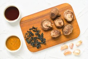 The ingredients for homemade fish sauce gathered on a white surface on a cutting board.