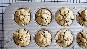 Just-baked Pancake Muffins cooking in a muffin pan, sitting on a black wire rack.