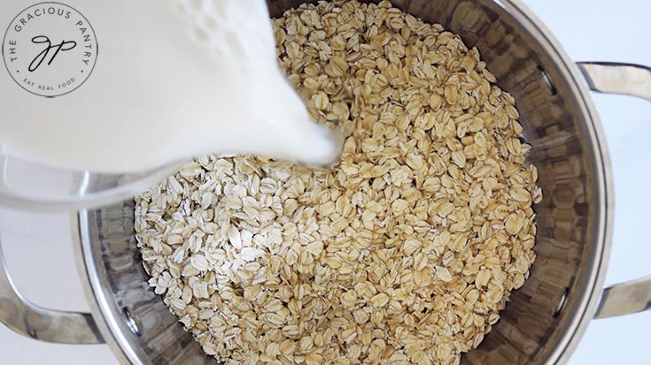 Pouring milk into a pot of dry oats.