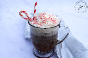 A just-made peppermint latte topped with whipped cream and crushed candy cane.