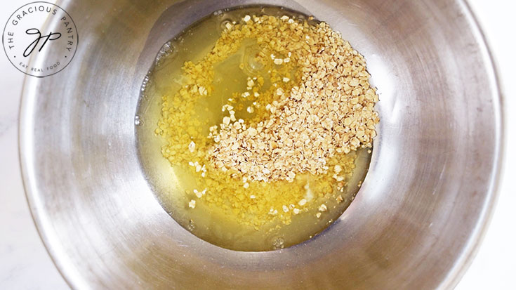 A mixing bowl with egg whites and oats in it.