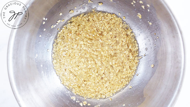 Egg whites and oats whisked together in a mixing bowl.