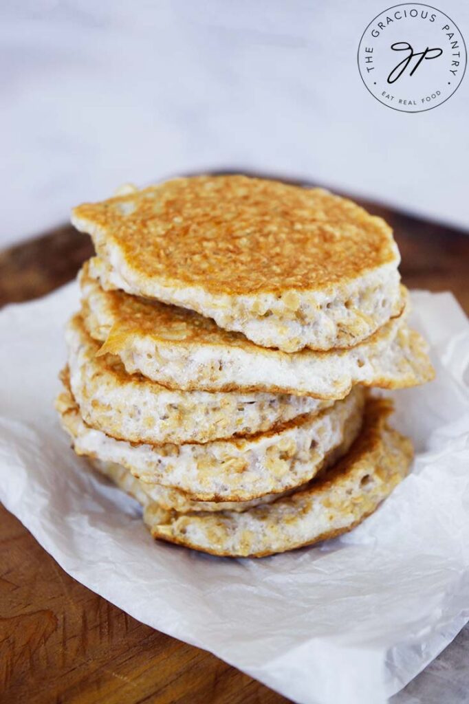 A stack of plain protein pancakes without toppings sitting on a piece of parchment paper.