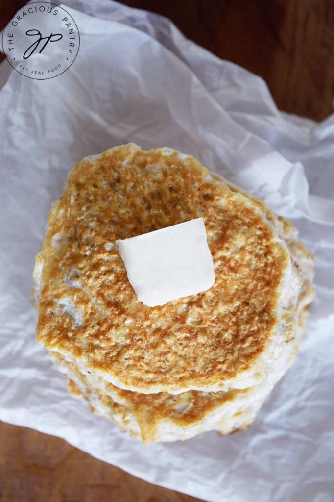 An overhead view of a stack or healthy protein pancakes with a pat of butter on top.