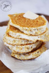 A close up of a stack of protein pancakes with a pat of butter on the top pancake.