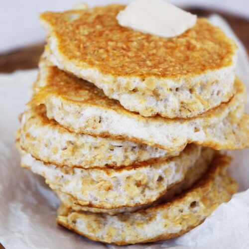 A close up of a stack of protein pancakes with a pat of butter on the top pancake.