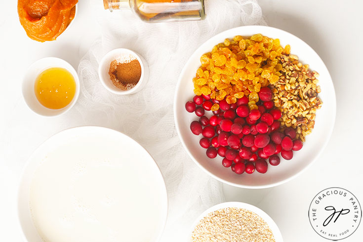 Pumpkin Baked Oatmeal Recipe ingredients sitting on a white surface in individual, white bowls.