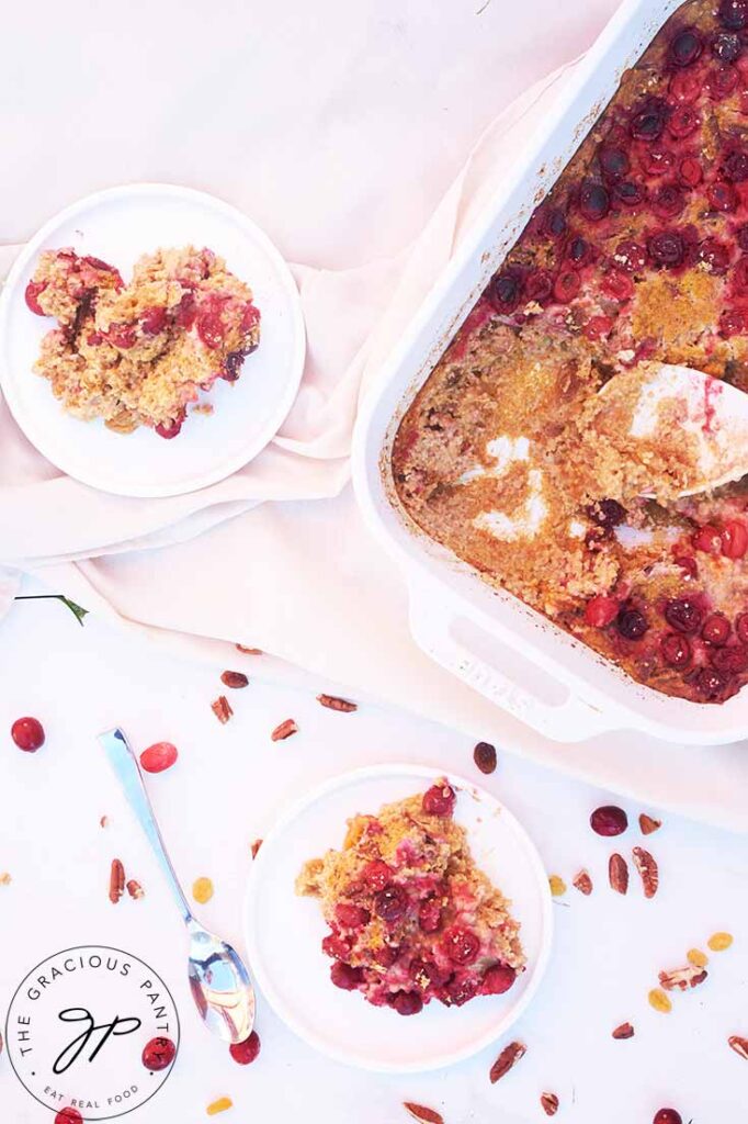 Two plates next to a casserole dish filled with Pumpkin Baked Oatmeal.