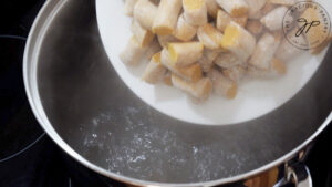 Putting raw gnocchi into a pot of boiling pasta water.