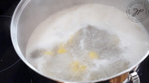 Gnocchi floating at the top of boiling water.
