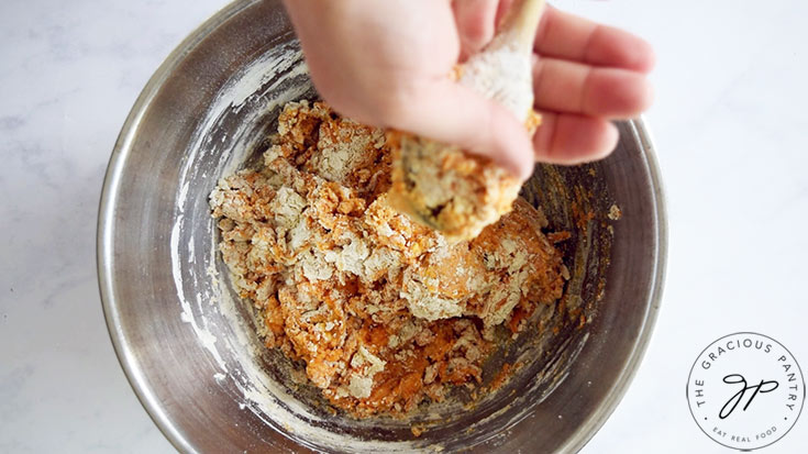 Scraping pumpkin gnocchi dough off a wooden spoon.