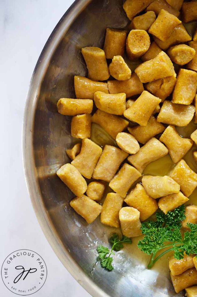 An overhead view looking down into a metal skillet filled with Pumpkin Gnocchi.