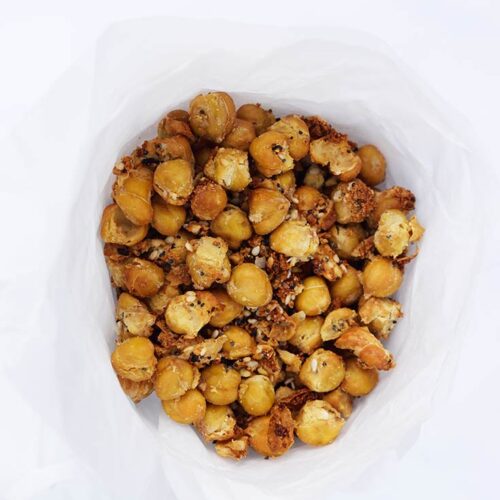 An overhead view looking down into a parchment cone filled with Roasted Everything Bagel Chickpeas.