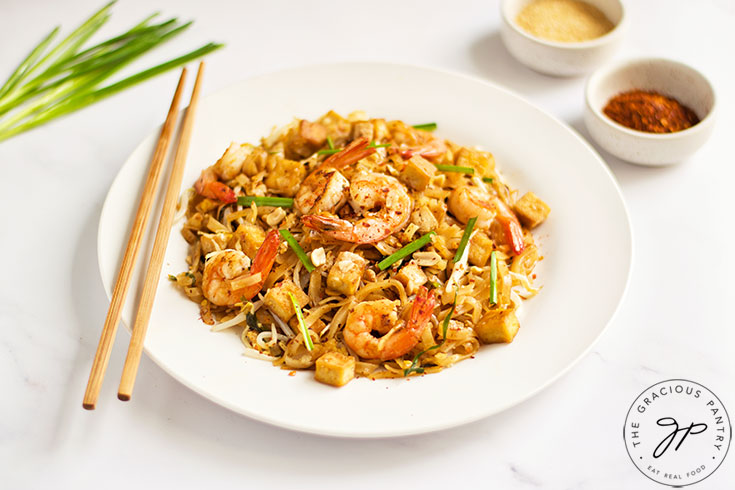 Shrimp Pad Thai served on a white plate with chopsticks.