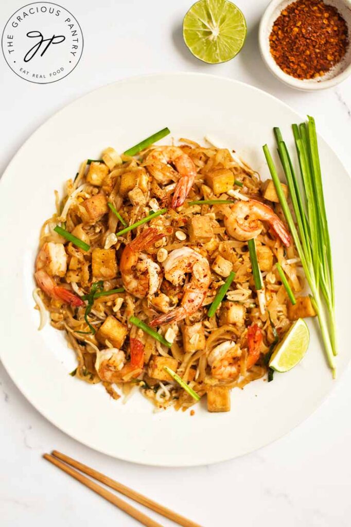 An overhead close up of a white plate filled with Shrimp Pad Thai.