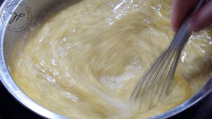 Whisking sick day soup in a large pot.