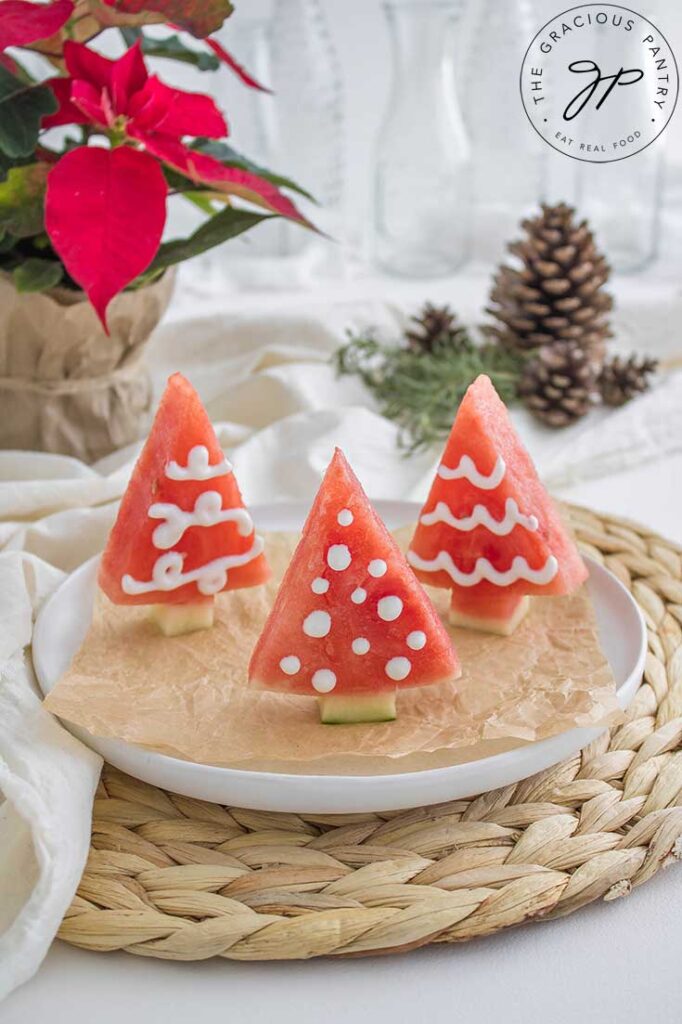 A white platter holds three Watermelon Christmas Trees.