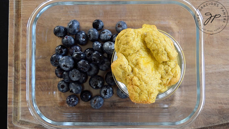 Air Fryer Scrambled Eggs in a container next to fresh blueberries.