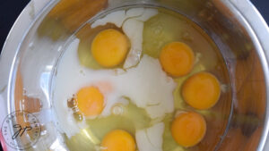 Milk added to eggs in a mixing bowl.