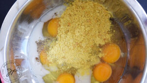 Spices added to eggs and milk in a mixing bowl.