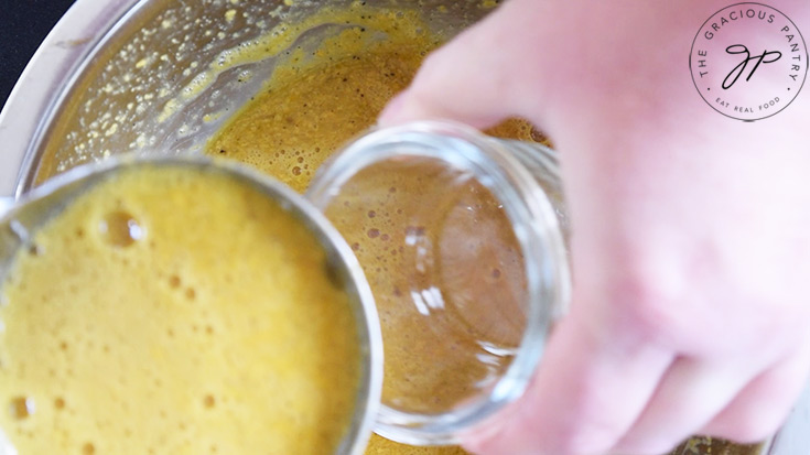 Ladling whisked eggs into oven-safe, glass containers.