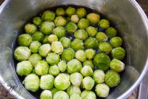 Brussels sprouts soaking in a bowl of water.