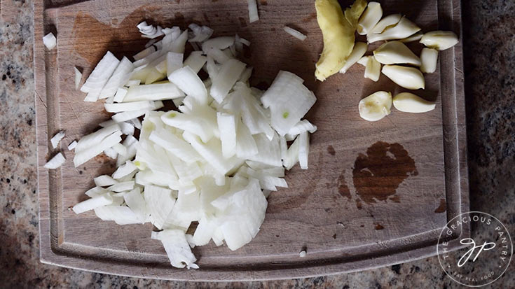 Chopped onions on a wooden cutting board.